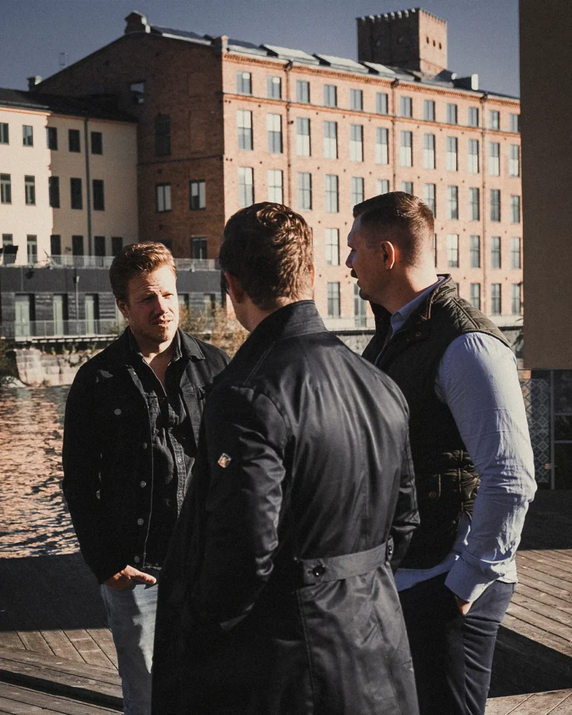 Tre medarbetare står vid Linköpings universitet vid Motala ström i Norrköping, de ser ut att diskutera någonting.
